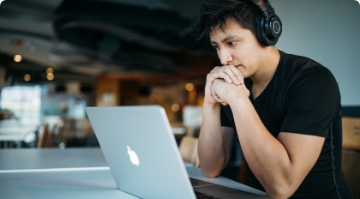 Asian man working on his laptop while sitting at a desk